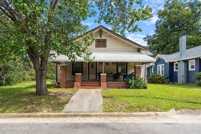 view of front of property featuring covered porch and a front lawn