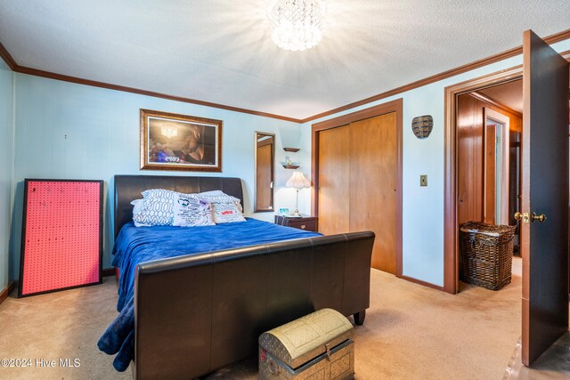 bedroom featuring carpet, a textured ceiling, a closet, and ornamental molding