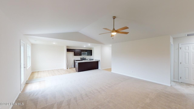 unfurnished living room with light carpet, ceiling fan, and vaulted ceiling