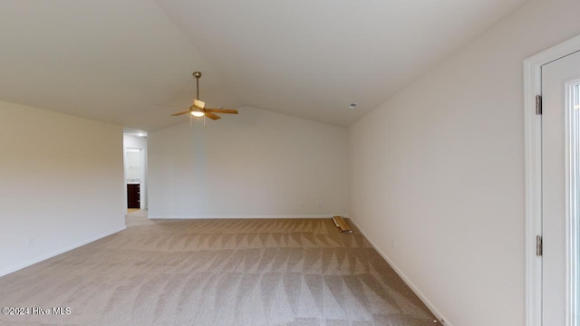 spare room featuring vaulted ceiling, ceiling fan, and light colored carpet