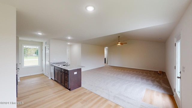 kitchen with sink, vaulted ceiling, dishwasher, light wood-type flooring, and dark brown cabinetry