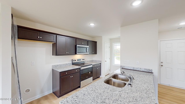 kitchen featuring light hardwood / wood-style flooring, sink, appliances with stainless steel finishes, and light stone countertops