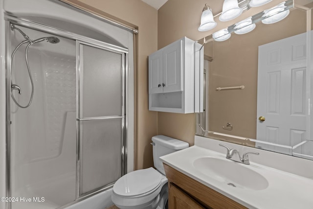 bathroom featuring vanity, toilet, and walk in shower