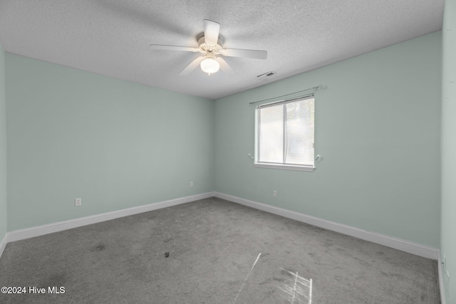 unfurnished room with ceiling fan, carpet floors, and a textured ceiling