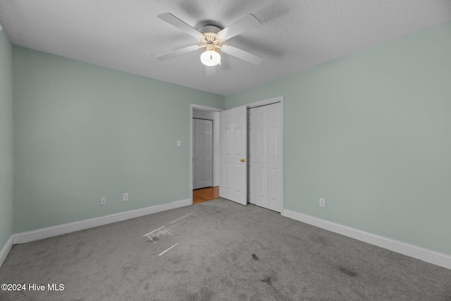 unfurnished bedroom with ceiling fan, light colored carpet, and a textured ceiling