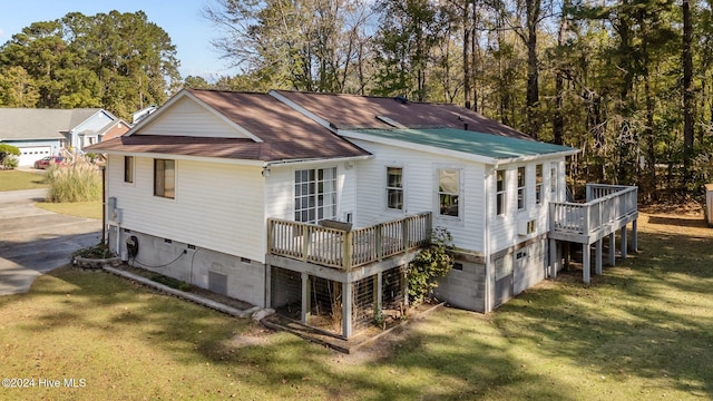 rear view of house with a lawn and a wooden deck