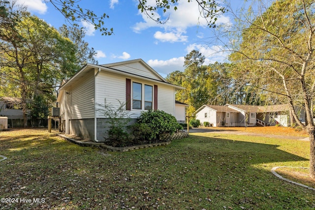 view of side of home with a yard