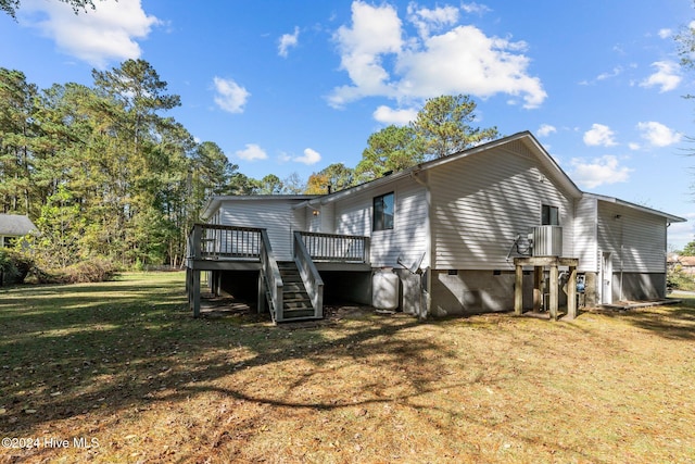 back of property with a yard and a wooden deck