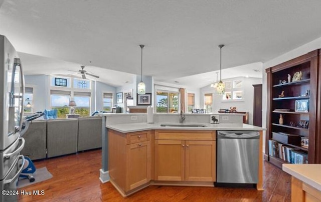 kitchen featuring appliances with stainless steel finishes, vaulted ceiling, dark wood-type flooring, and sink