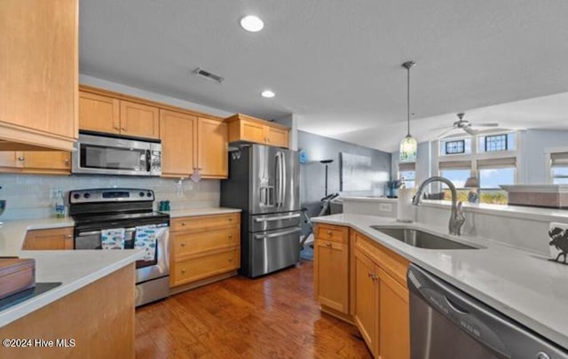 kitchen featuring sink, hanging light fixtures, ceiling fan, wood-type flooring, and stainless steel appliances