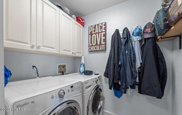 laundry area with washer and clothes dryer and cabinets