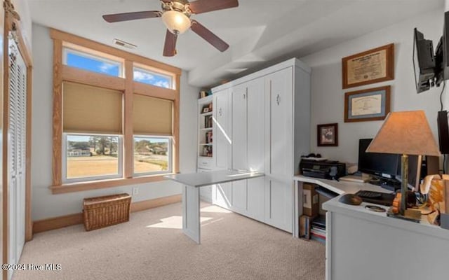 carpeted office space featuring ceiling fan