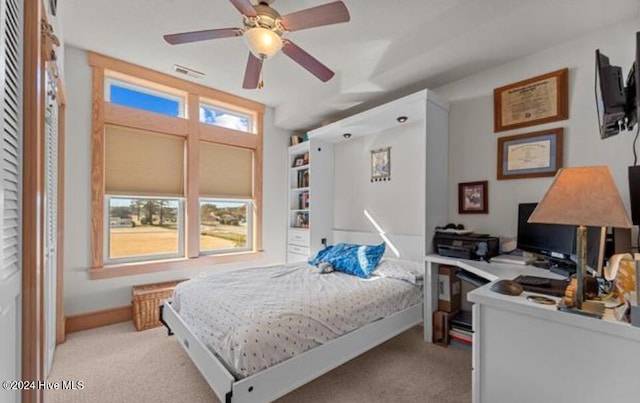 bedroom featuring multiple windows, ceiling fan, and light colored carpet