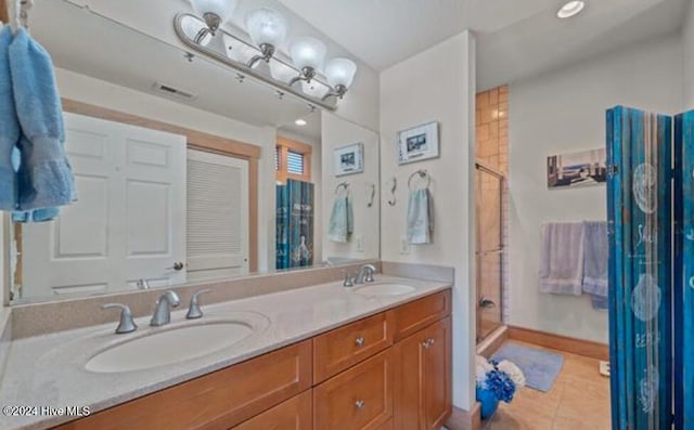 bathroom featuring tile patterned flooring, vanity, and a shower with door