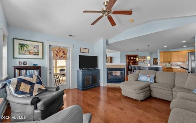 living room with hardwood / wood-style floors, vaulted ceiling, and ceiling fan