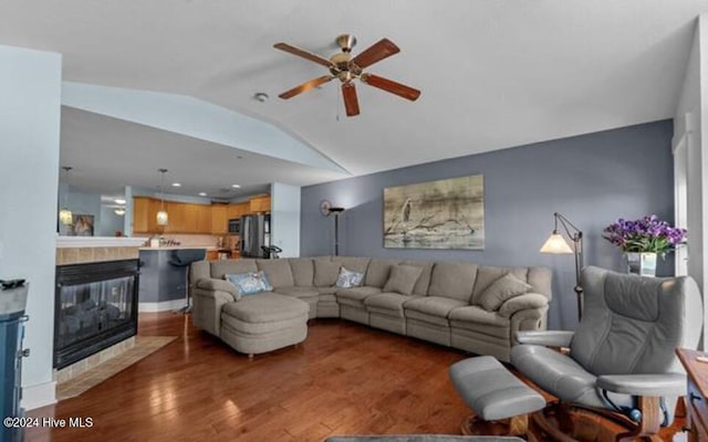 living room featuring a tiled fireplace, ceiling fan, wood-type flooring, and lofted ceiling