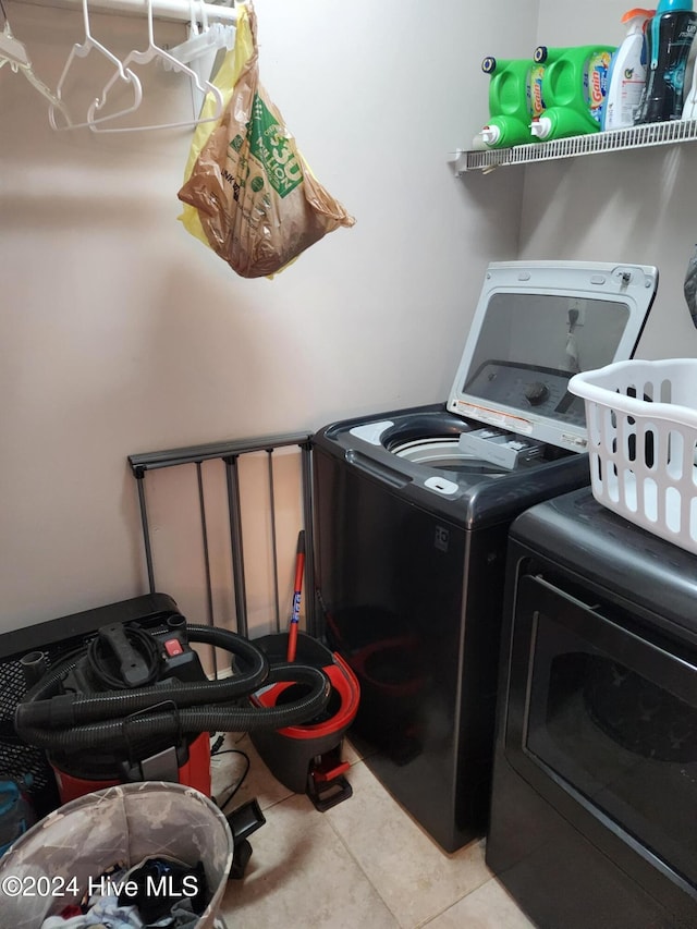 laundry room featuring light tile patterned flooring and washing machine and clothes dryer