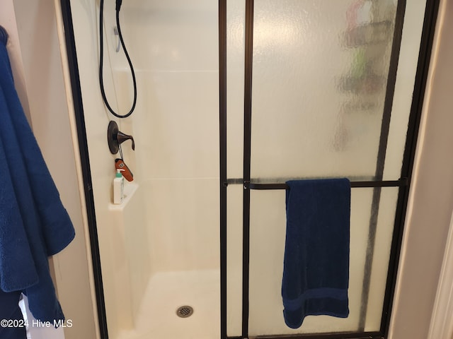 bathroom with a shower with door