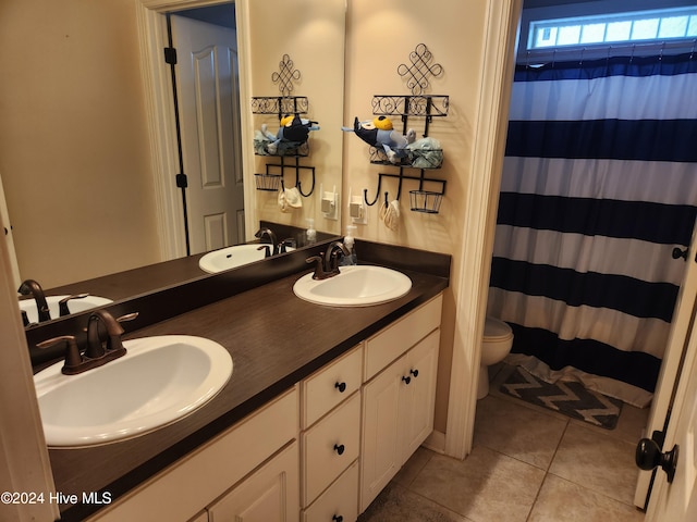 bathroom with tile patterned flooring, vanity, toilet, and curtained shower