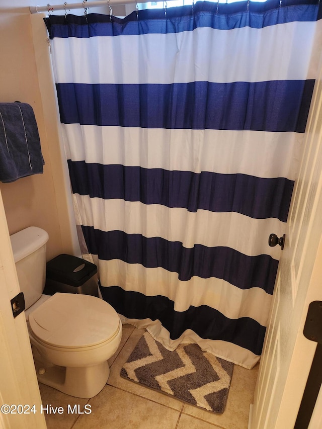 bathroom featuring tile patterned floors, toilet, and a shower with shower curtain