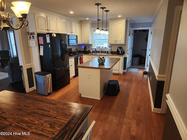 kitchen featuring crown molding, dark wood-type flooring, black appliances, decorative light fixtures, and a center island