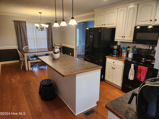 kitchen featuring a kitchen island, crown molding, a textured ceiling, white cabinets, and black appliances