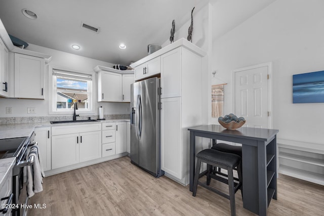 kitchen featuring white cabinets, appliances with stainless steel finishes, light hardwood / wood-style flooring, and sink