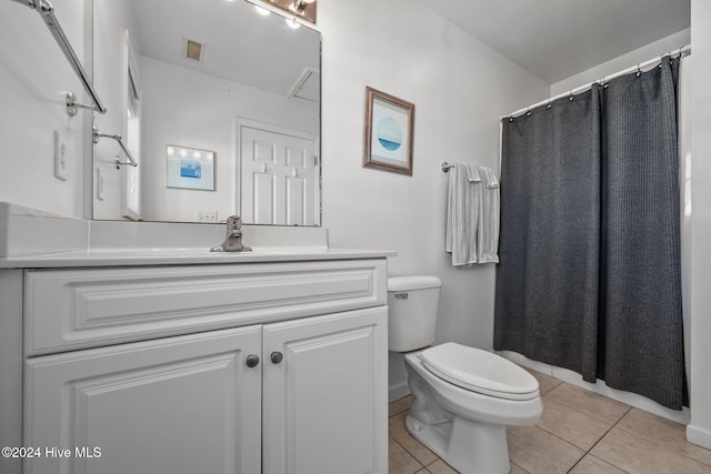 bathroom featuring tile patterned flooring, vanity, toilet, and walk in shower