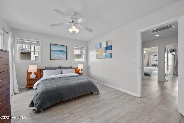 bedroom featuring multiple windows, light hardwood / wood-style floors, and ceiling fan