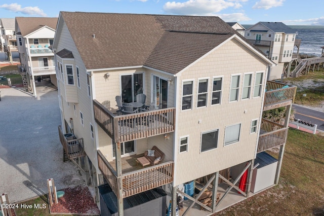 back of house with a balcony and a water view