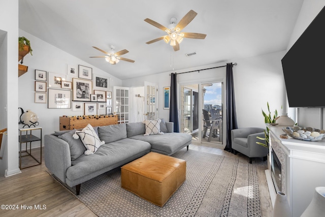 living room with wood-type flooring, vaulted ceiling, and ceiling fan