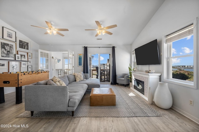 living room featuring ceiling fan, light hardwood / wood-style flooring, and lofted ceiling