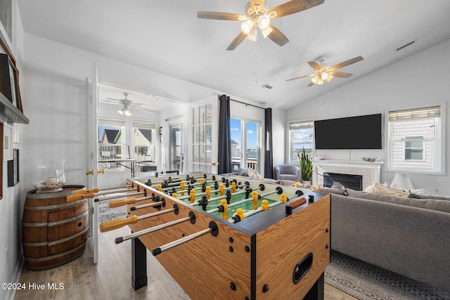 rec room with vaulted ceiling, light hardwood / wood-style flooring, and ceiling fan