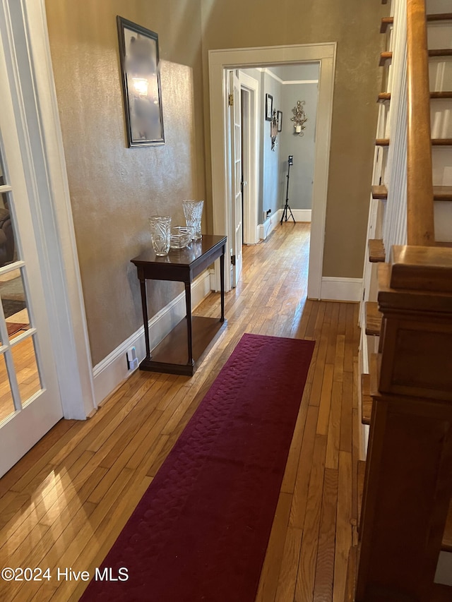 corridor featuring light hardwood / wood-style flooring and ornamental molding