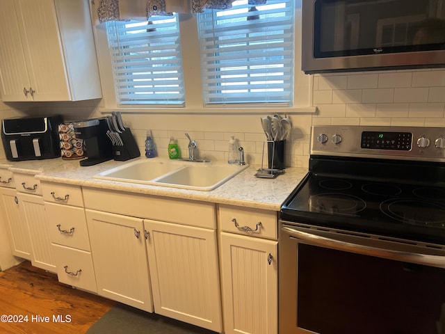 kitchen featuring backsplash, dark hardwood / wood-style flooring, sink, and appliances with stainless steel finishes