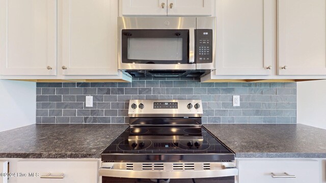 kitchen with appliances with stainless steel finishes, dark countertops, white cabinetry, and decorative backsplash