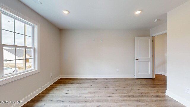 spare room with recessed lighting, baseboards, and wood finished floors