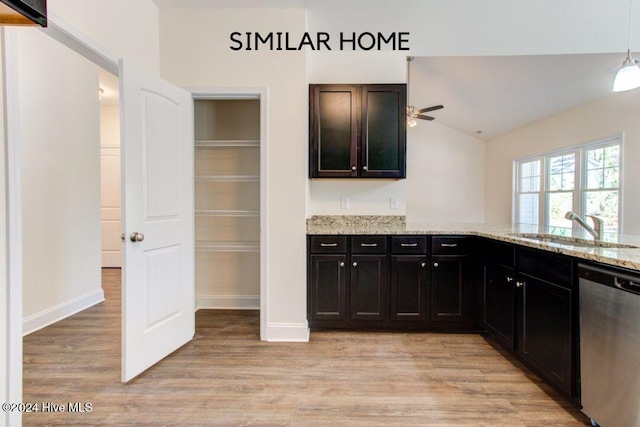 kitchen with sink, light stone counters, light hardwood / wood-style flooring, stainless steel dishwasher, and vaulted ceiling