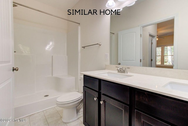 bathroom with tile patterned flooring, vanity, toilet, and walk in shower