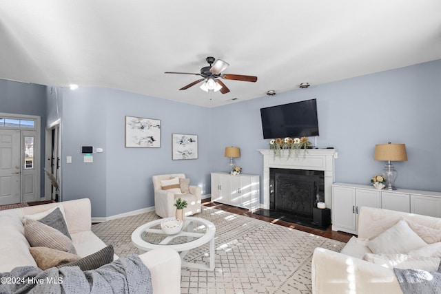 living room with ceiling fan and dark hardwood / wood-style flooring