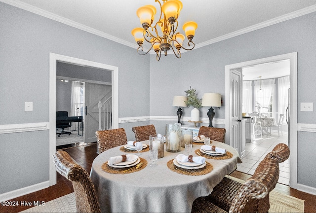 dining area featuring a notable chandelier, light wood-type flooring, and ornamental molding