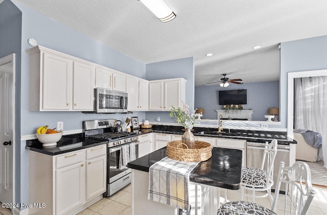 kitchen with kitchen peninsula, white cabinets, and stainless steel appliances