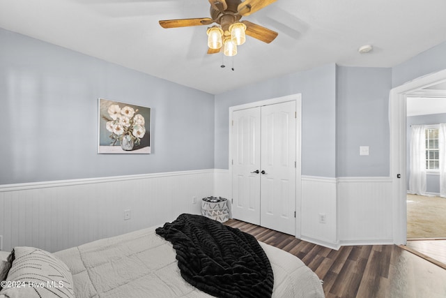 bedroom with ceiling fan, dark hardwood / wood-style flooring, and a closet