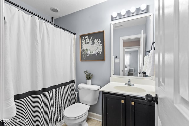 bathroom featuring a textured ceiling, vanity, and toilet