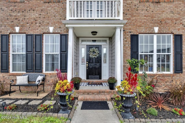 view of exterior entry featuring a balcony