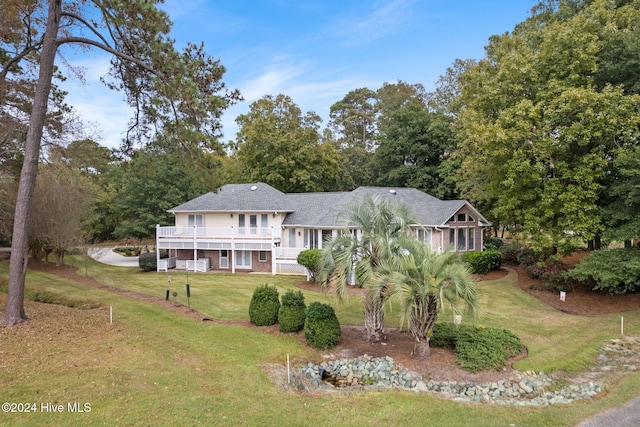 view of front facade featuring a front yard and a sunroom