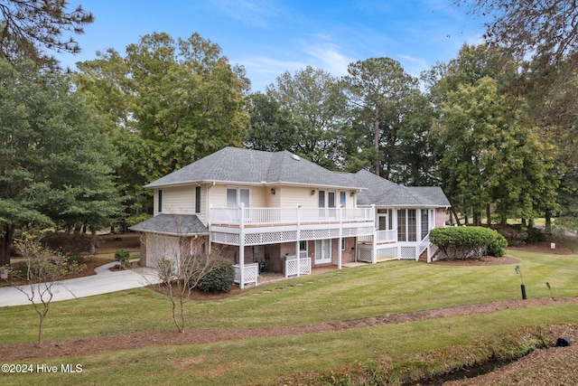 view of front of home with a sunroom, a front lawn, and a deck