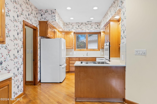 kitchen featuring white appliances, light hardwood / wood-style floors, and sink