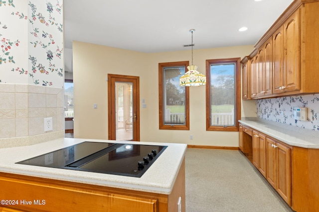 kitchen with kitchen peninsula, black electric cooktop, hanging light fixtures, and light colored carpet