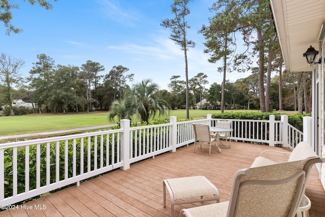 wooden terrace featuring a lawn